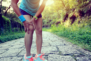 woman runner hold her sports injured knee